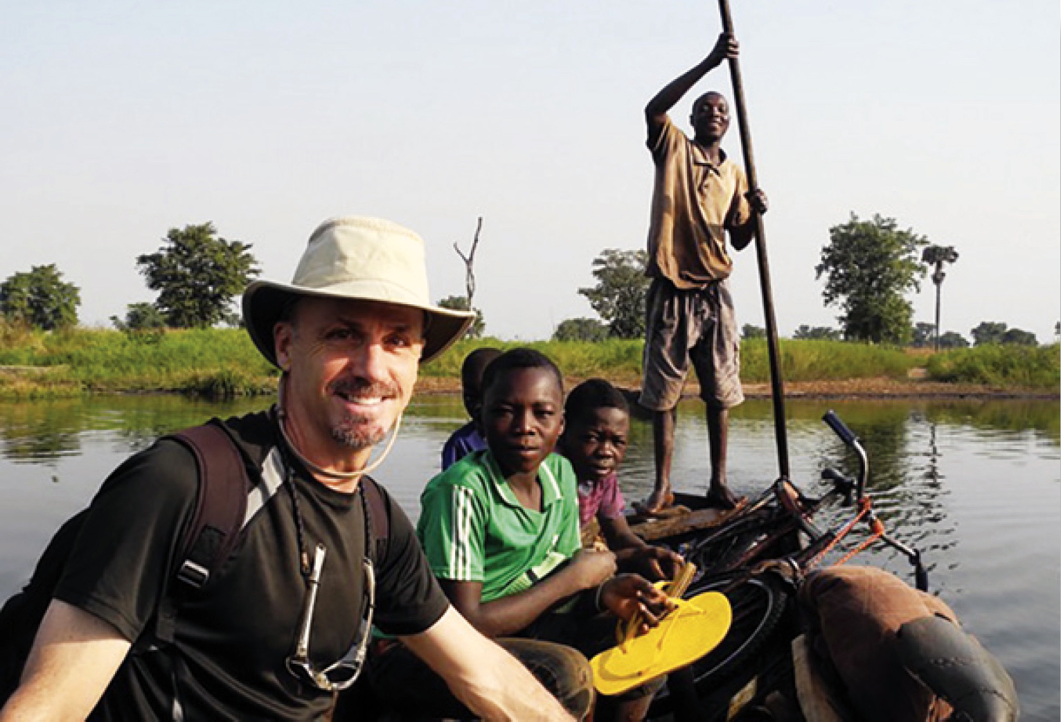 Fr David Bohnsack sits on a boat with an African family.