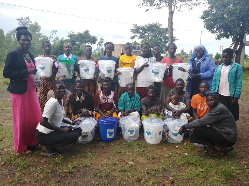 A group of Ugandan women pose with their new filters and buckets.